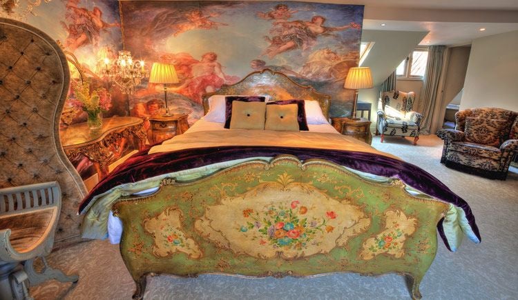 Elegant boutique hotel room with plush white bedding, exposed brick walls, and soft ambient lighting in a historic United Kingdom property