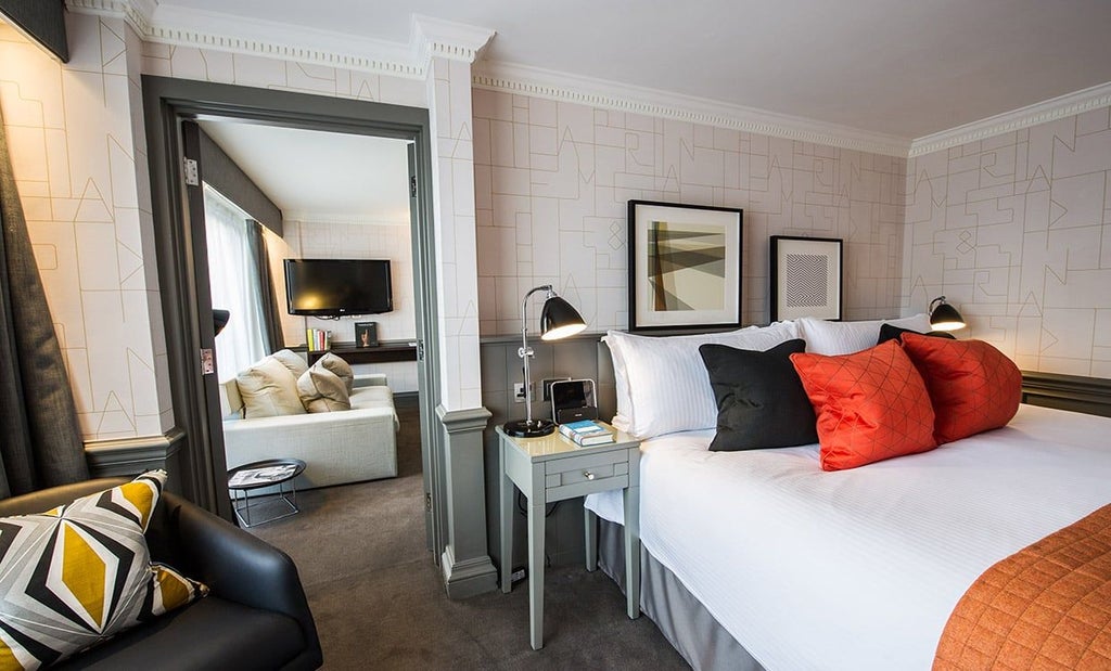 Elegant boutique hotel suite with contemporary design, crisp white linens, plush bedding, and modern artwork in a sophisticated United Kingdom luxury accommodation.