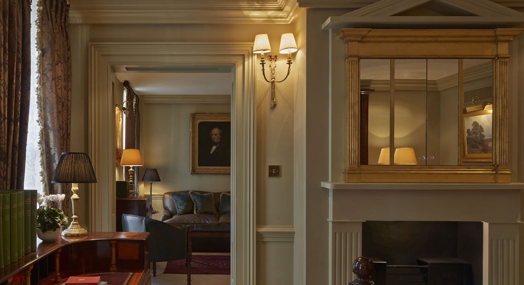 Ornate Georgian-style bedroom with plush velvet furnishings, antique chandelier, and rich emerald green walls at a luxury boutique hotel in London