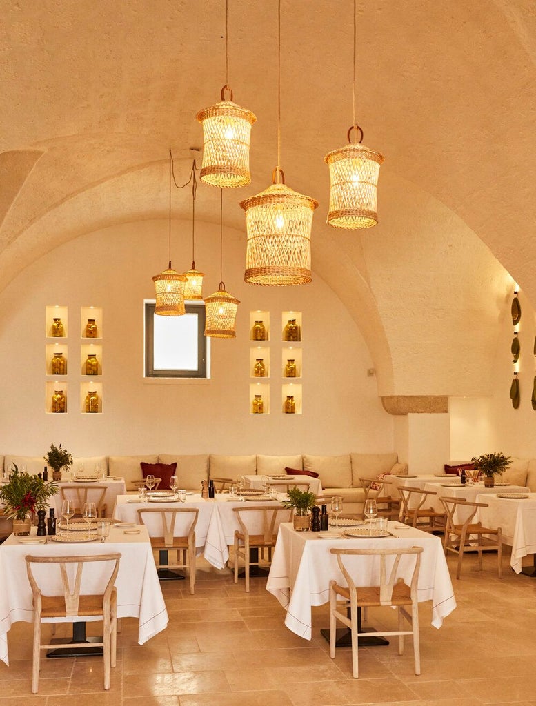 Rustic luxury stone villa nestled in Puglia's countryside, with sun-drenched terracotta walls, elegant arched windows, and lush Mediterranean gardens.