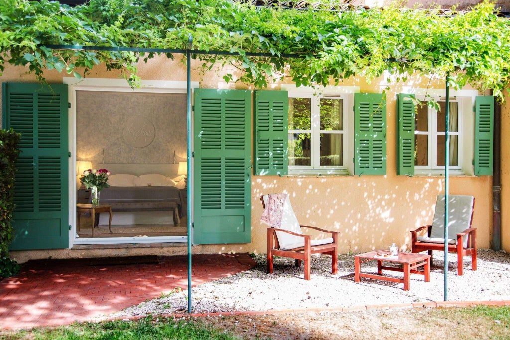 Elegant stone facade of historic Provençal monastery-turned-luxury hotel nestled among lush gardens in scenic French countryside at sunset