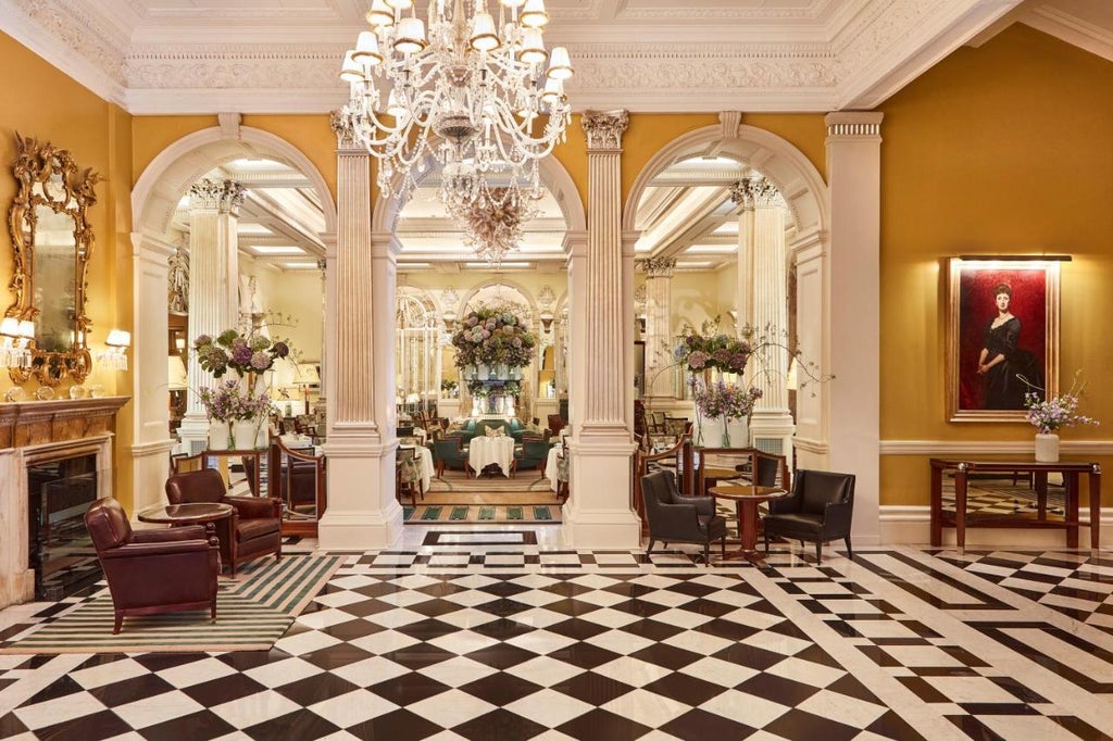 Claridge's Hotel's grand Art Deco facade illuminated at dusk, with its iconic revolving door entrance and black awnings in Mayfair, London