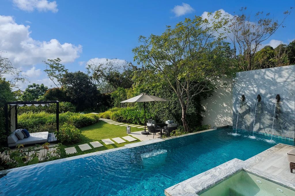 Spacious villa bedroom with panoramic windows, private pool view, king bed, white linens, and elegant Thai-inspired décor accents