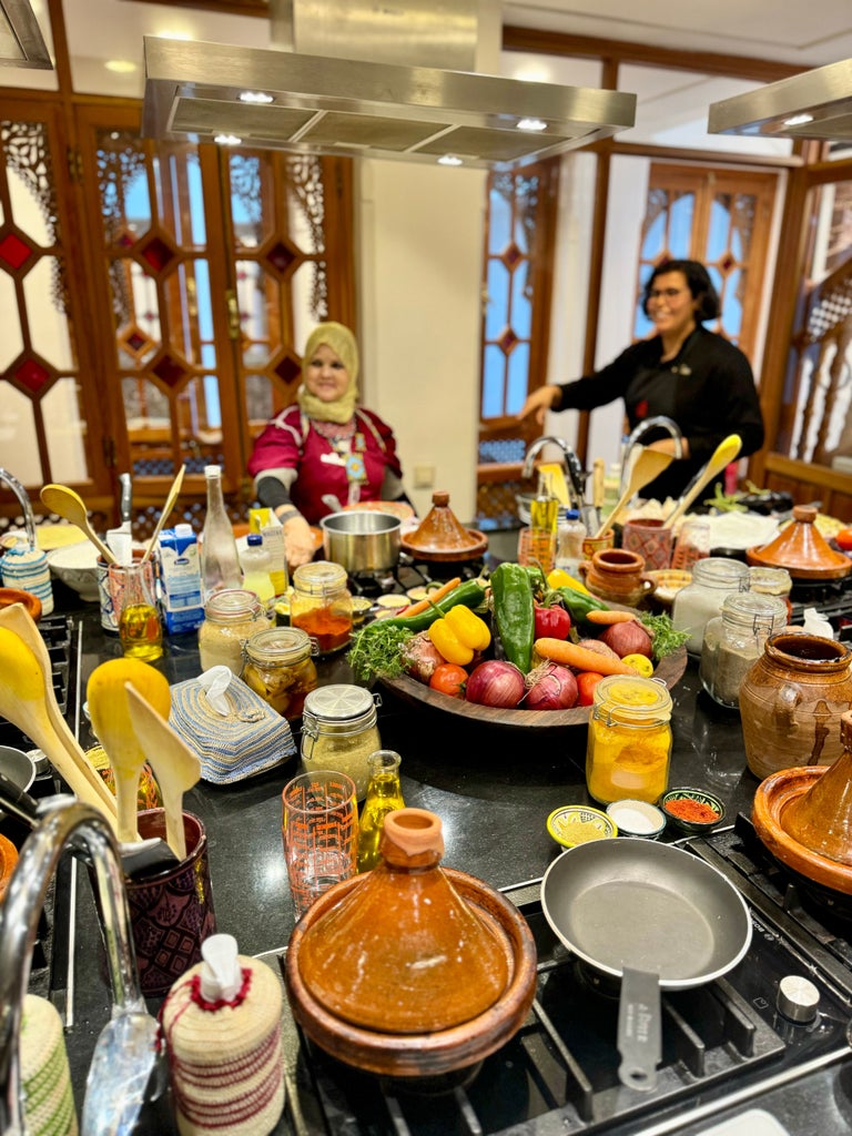 Vibrant cooking class in Moroccan kitchen, chefs in crisp white aprons surrounded by colorful spices, traditional tagines, and gleaming copper cookware