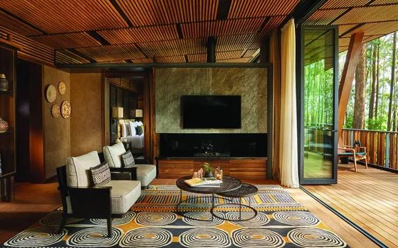 Luxurious Virunga Suite at One&Only Gorilla's Nest, featuring elegant wood furnishings, floor-to-ceiling windows overlooking lush Rwandan rainforest landscape