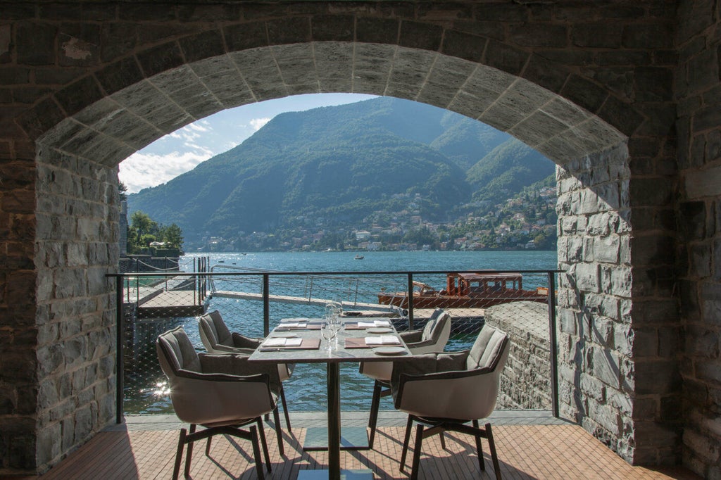 Modern luxury hotel overlooking Lake Como with minimalist stone and wood facade, infinity pool merging with lake views at sunset