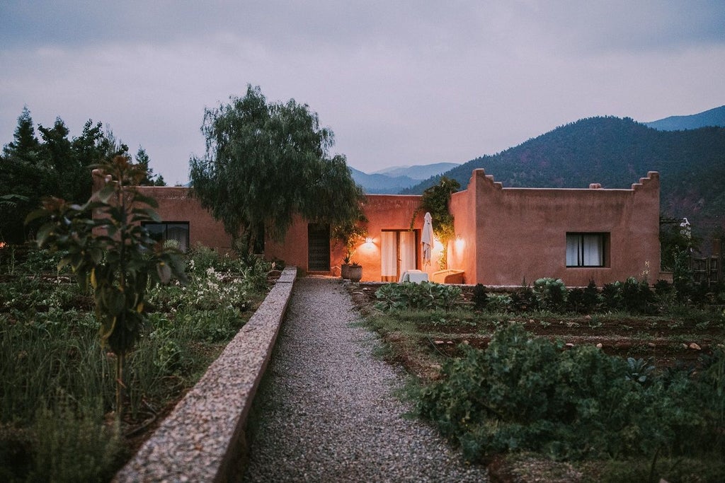 Traditional Moroccan fortress hotel nestled in Atlas Mountains, featuring terracotta walls, palm gardens and panoramic valley views