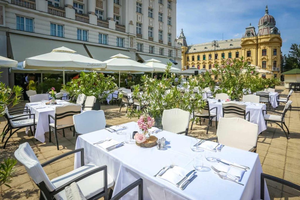 Modern coastal hotel with elegant white facade, panoramic sea-view balconies, and manicured palm gardens along pristine Adriatic shore