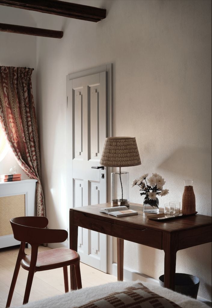 Rustic luxury corner room at Bethlen Estates, featuring exposed wooden beams, elegant white bedding, and traditional Transylvanian architectural details