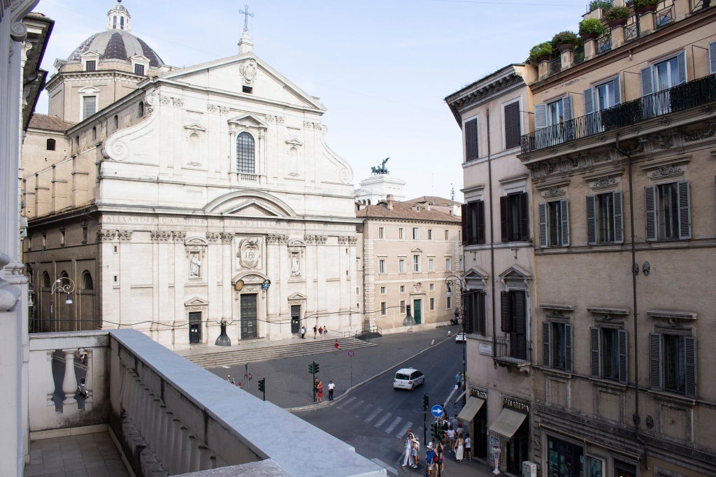 Elegant Italian luxury suite with classic architectural details, soft neutral color palette, ornate chandelier, and plush furnishings in historic boutique accommodation