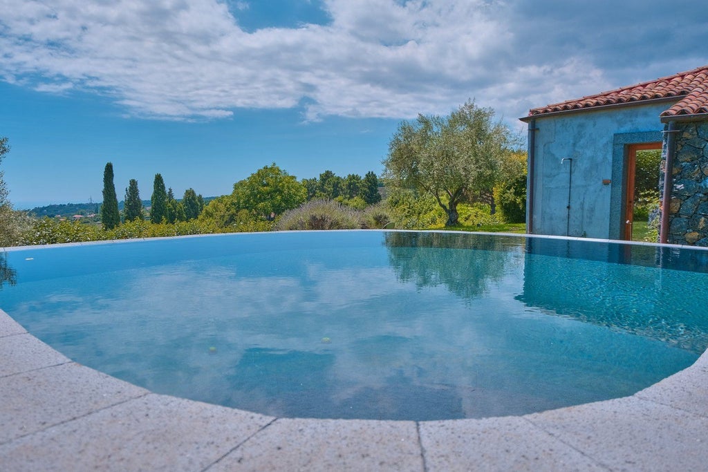 Luxurious four-bedroom pool villa with rustic Sicilian design, stone walls, elegant furnishings, and scenic vineyard landscape at Monaci delle Terre Nere