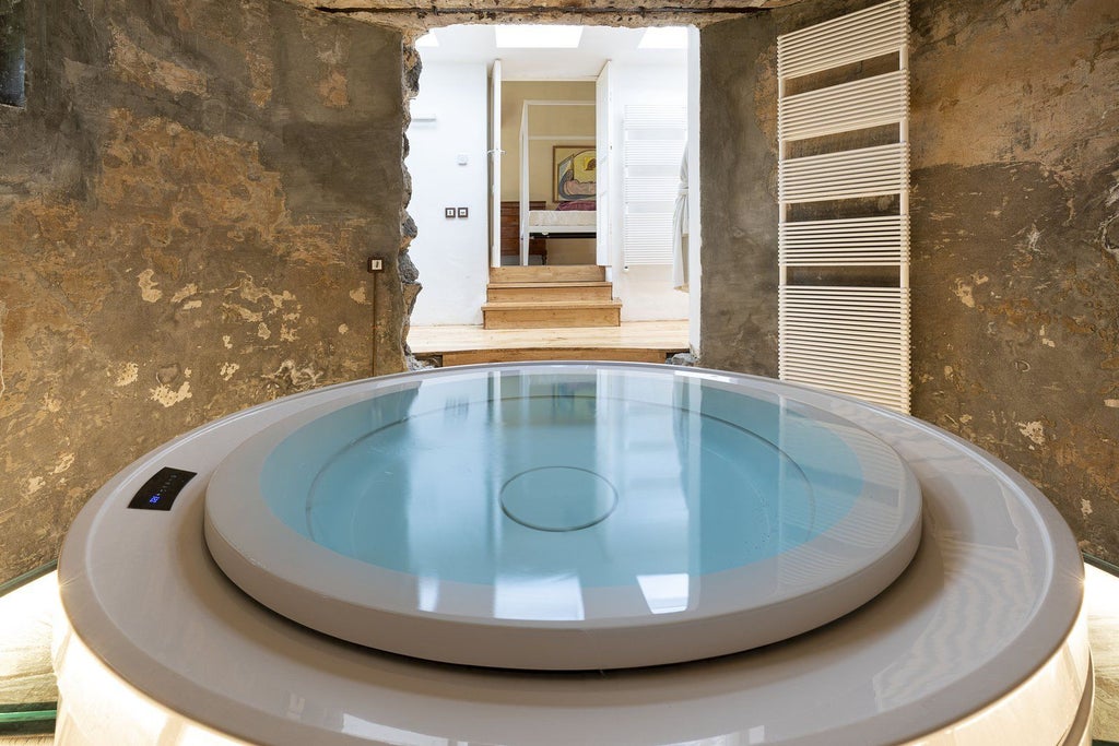 Luxurious Sicilian villa with rustic stone walls, private infinity pool overlooking verdant volcanic landscape at Monaci delle Terre Nere resort