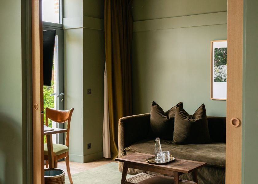 Luxurious Cassiopée Suite at Les Sources de Cheverny, featuring elegant beige and cream decor, plush bedding, and refined French countryside design details