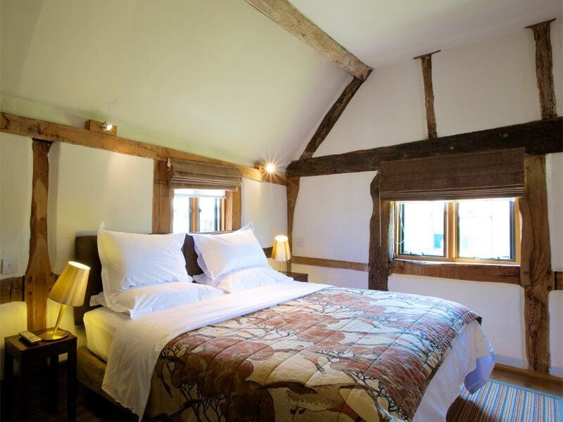 Elegant luxury hotel room with plush white bedding, modern wood furniture, and soft ambient lighting at Scenset Manor in United Kingdom