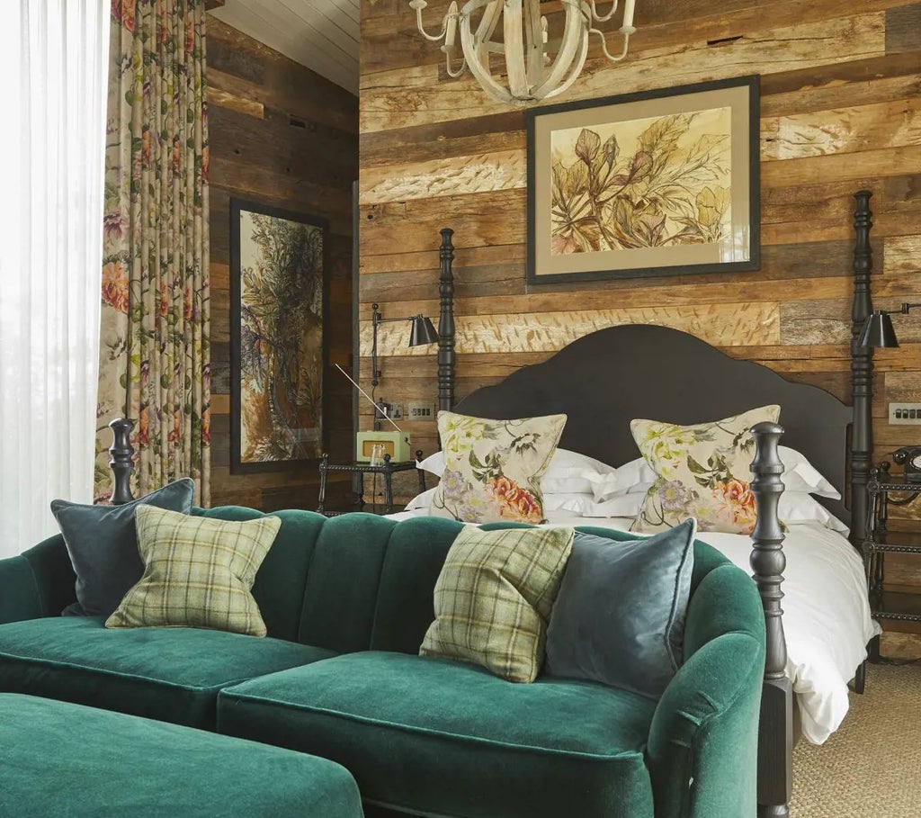 Luxurious Lake Cabin at Lime Wood, UK, featuring elegant wood-paneled walls, plush king-sized bed, and panoramic forest views through large windows.