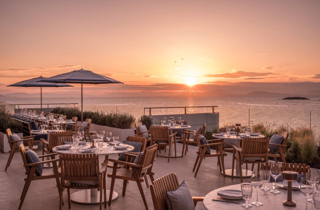 Stunning beachfront resort complex with infinity pools overlooking crystal blue Mediterranean waters and manicured gardens at sunset