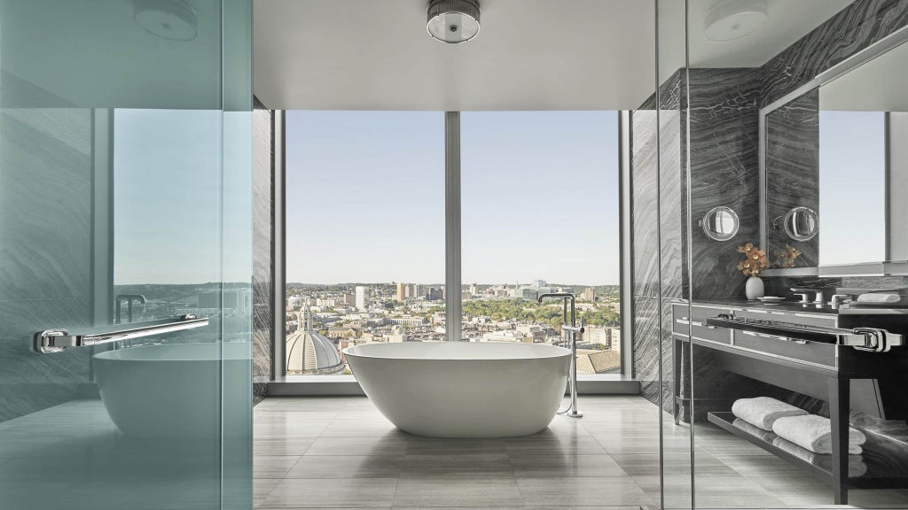 Spacious presidential suite with panoramic city views, elegant king bed, marble bathroom, and floor-to-ceiling windows at luxurious scenset hotel in Boston