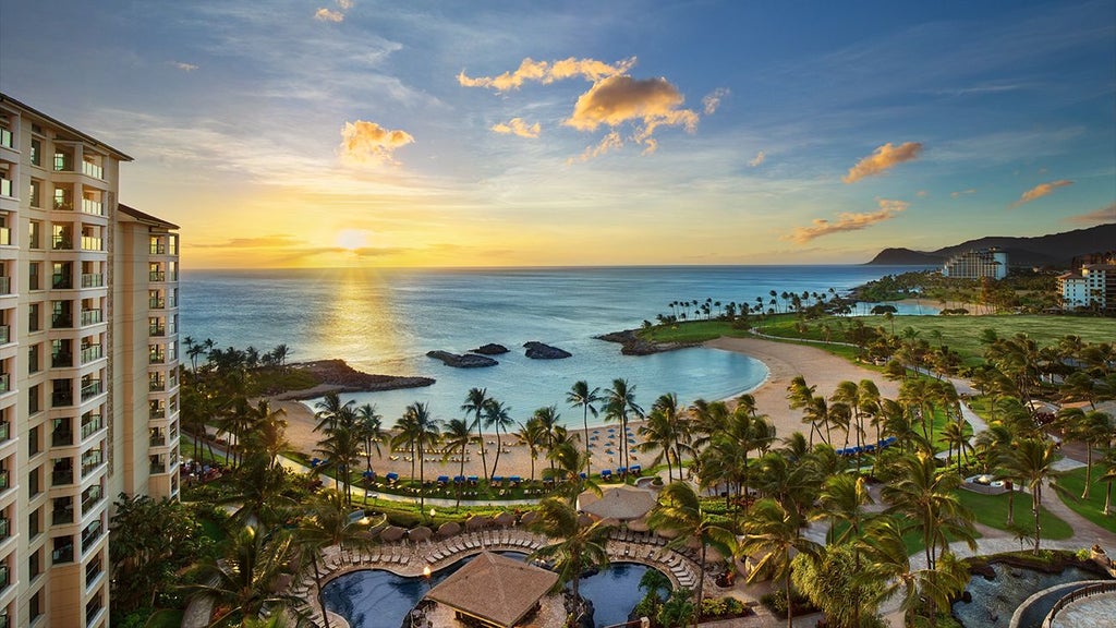 Luxurious beachfront resort with palm trees, azure waters, and modern Hawaiian-style architecture at a tropical paradise in Ko Olina, Hawaii.