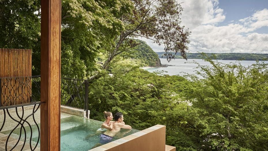 Luxurious suite with private infinity plunge pool overlooking lush Costa Rican rainforest canopy, featuring modern tropical decor