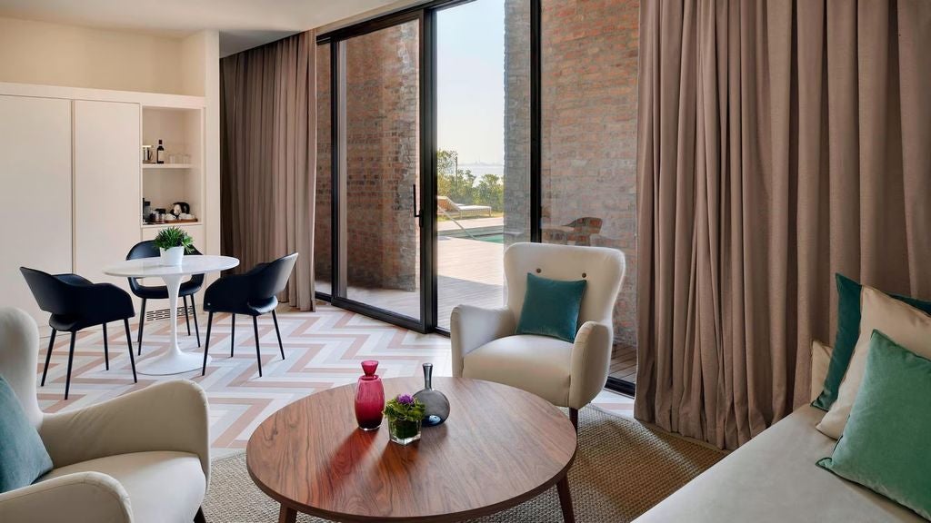 Luxurious pool suite at JW Marriott Venice featuring a private plunge pool, modern loungers, and manicured gardens with lagoon views