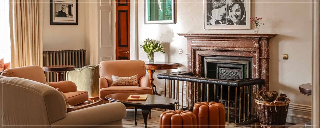 Elegant hotel suite with plush king bed, panoramic windows overlooking scenic Irish landscape, rich wood furnishings, and soft neutral color palette