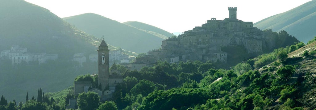 Rustic stone buildings of Sextantio Albergo Diffuso nestled in rugged Italian mountain landscape, showcasing traditional architectural charm and scenic tranquility