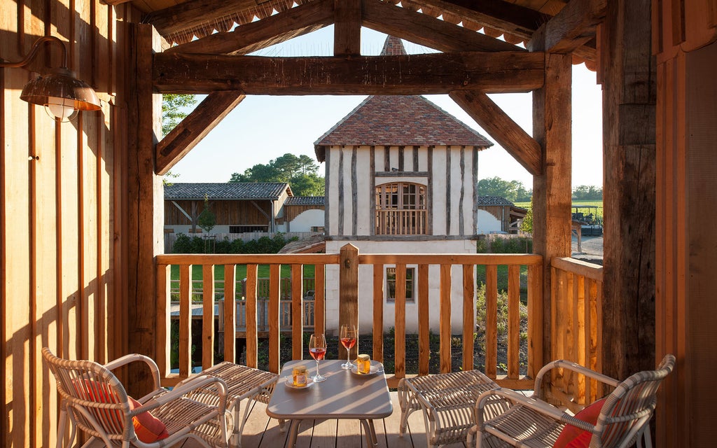 Upscale French country hotel with stone facade, surrounded by vineyards and a tranquil lake reflecting the elegant building at sunset