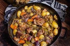 Local cook demonstrating traditional Croatian cooking methods in rustic stone kitchen with fresh ingredients and copper cookware