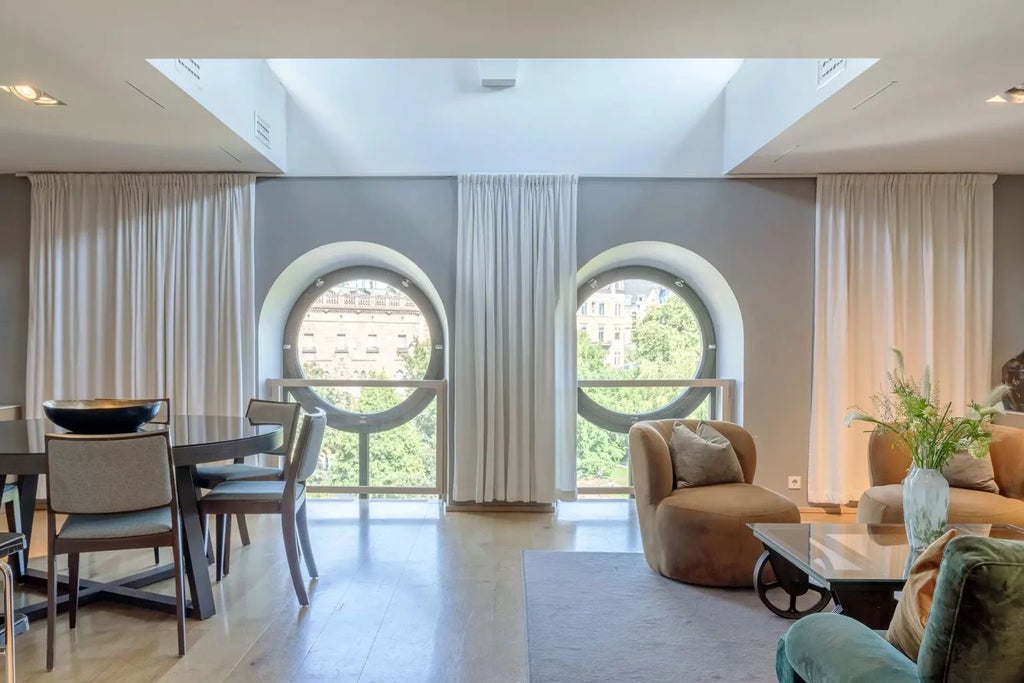 Elegant clock-themed hotel suite at Scenset's Berns Hotel, featuring vintage timepiece, luxurious dark wood furnishings, and sophisticated monochromatic decor