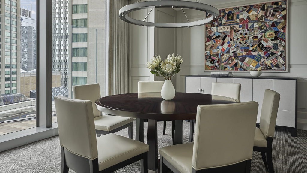 Elegant Charles Suite at Four Seasons One Dalton Street, featuring panoramic city views, modern decor, plush king bed, and sleek marble bathroom in Boston