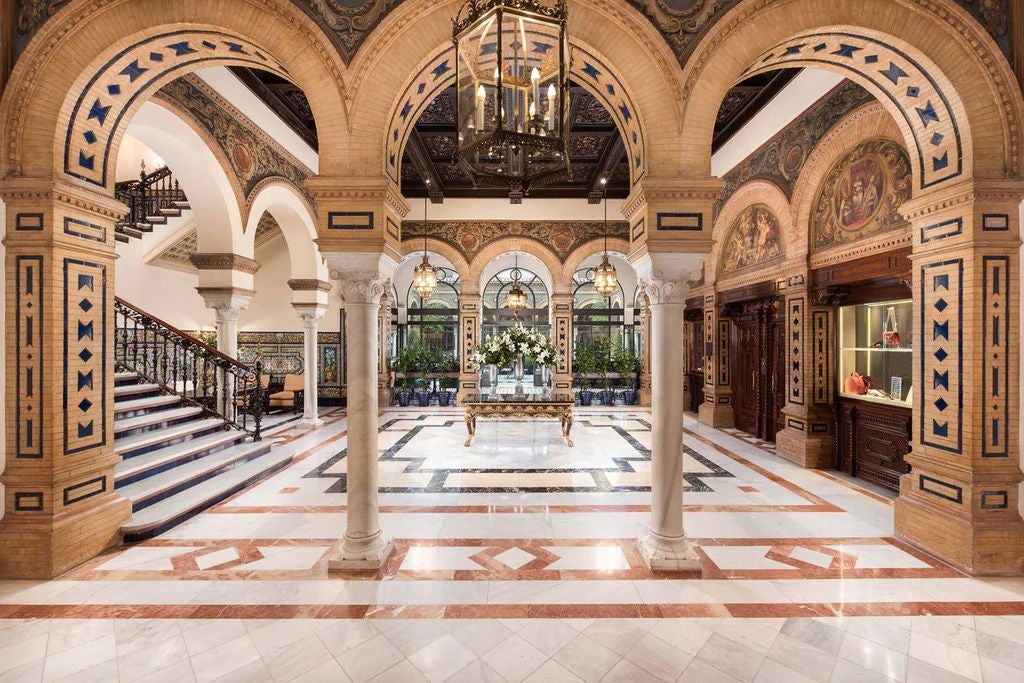 Ornate Moorish-style courtyard at Hotel Alfonso XIII, featuring marble columns, arched walkways, and decorative tile work in Seville, Spain