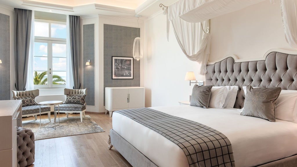 Elegant Lake Garda view hotel room with king bed, marble floors, and floor-to-ceiling windows showcasing expansive waterfront vistas