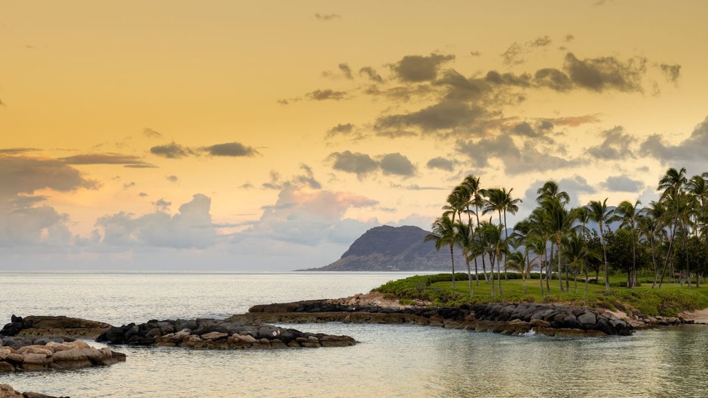 Luxurious beachfront resort at Ko Olina, featuring modern Hawaiian-inspired architecture, crystal-clear pool, and pristine white sandy shoreline with azure ocean backdrop