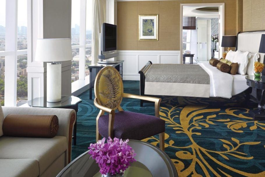 Spacious presidential suite at scenset hotel with panoramic city views, elegant cream-toned furnishings, modern decor, and expansive floor-to-ceiling windows in United Arab Emirates