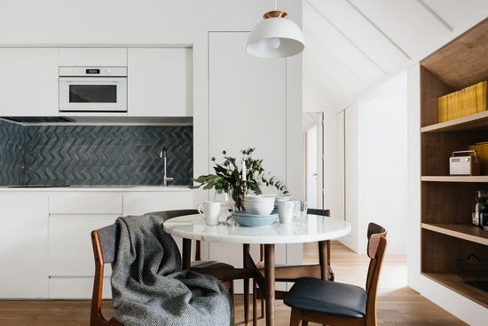 Modern, minimalist one-bedroom apartment in Lisbon with sleek white furnishings, large windows, and elegant design showcasing Portuguese contemporary urban living space.