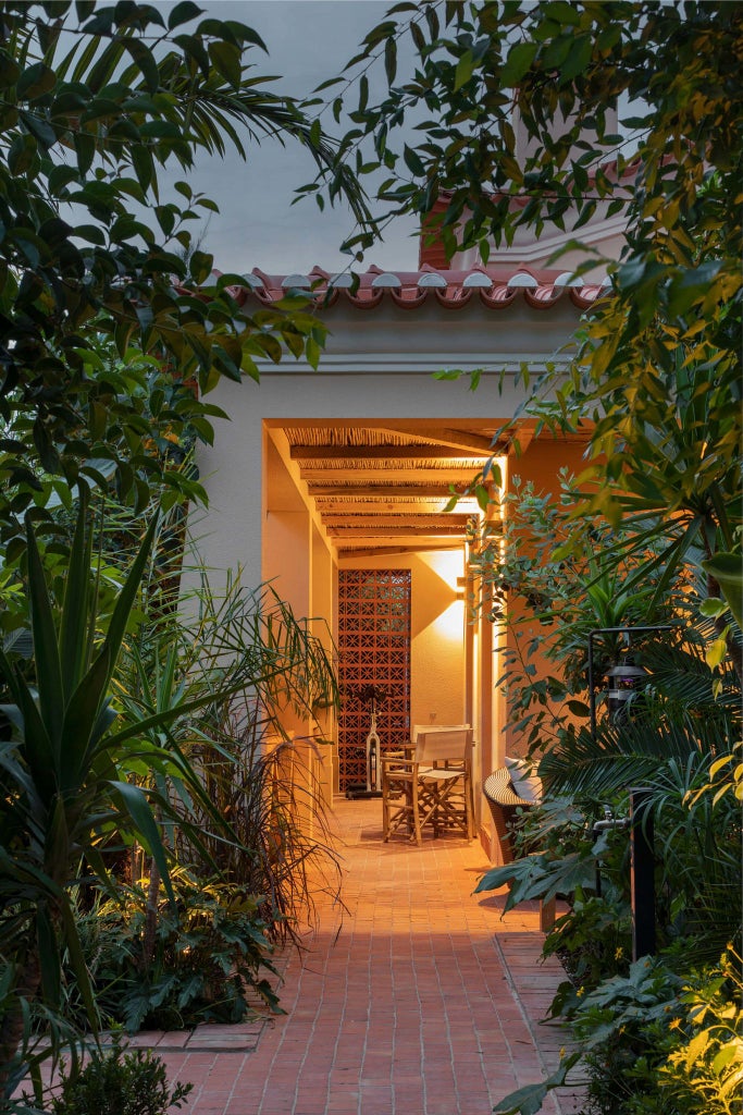 Luxurious stone country house with rustic terracotta roof, nestled in verdant Portuguese countryside with elegant spa architecture and lush gardens.