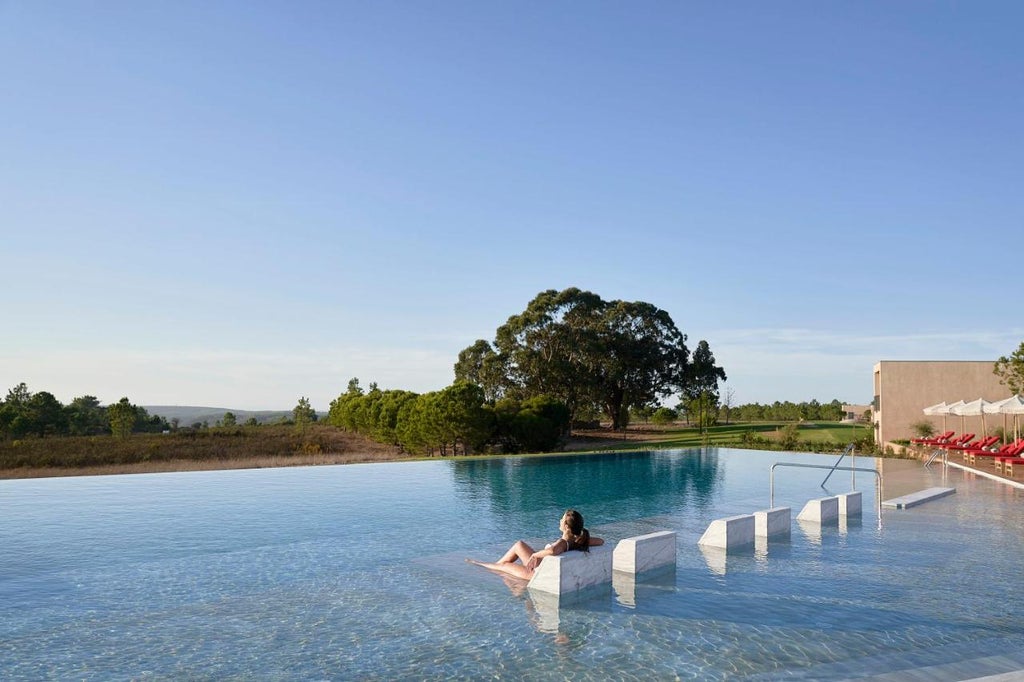 Luxury oceanfront resort with crisp white architecture, private balconies and infinity pool overlooking pristine Portuguese coastline