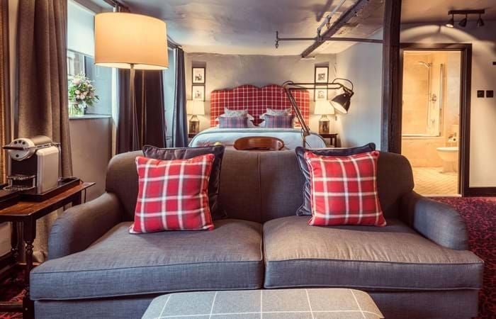 Elegant twin room at The Lygon Arms, featuring plush beds, classic British decor, crisp white linens, and traditional wooden furniture in a historic setting.