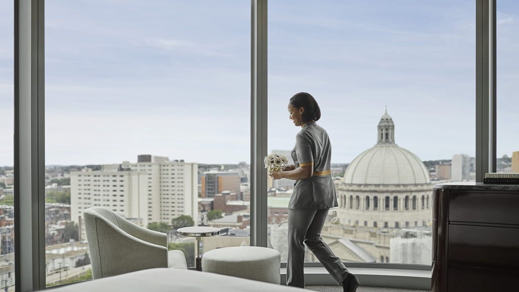 Luxurious Four Seasons corner suite overlooking Back Bay, featuring elegant contemporary design with plush king bed and floor-to-ceiling windows in Boston