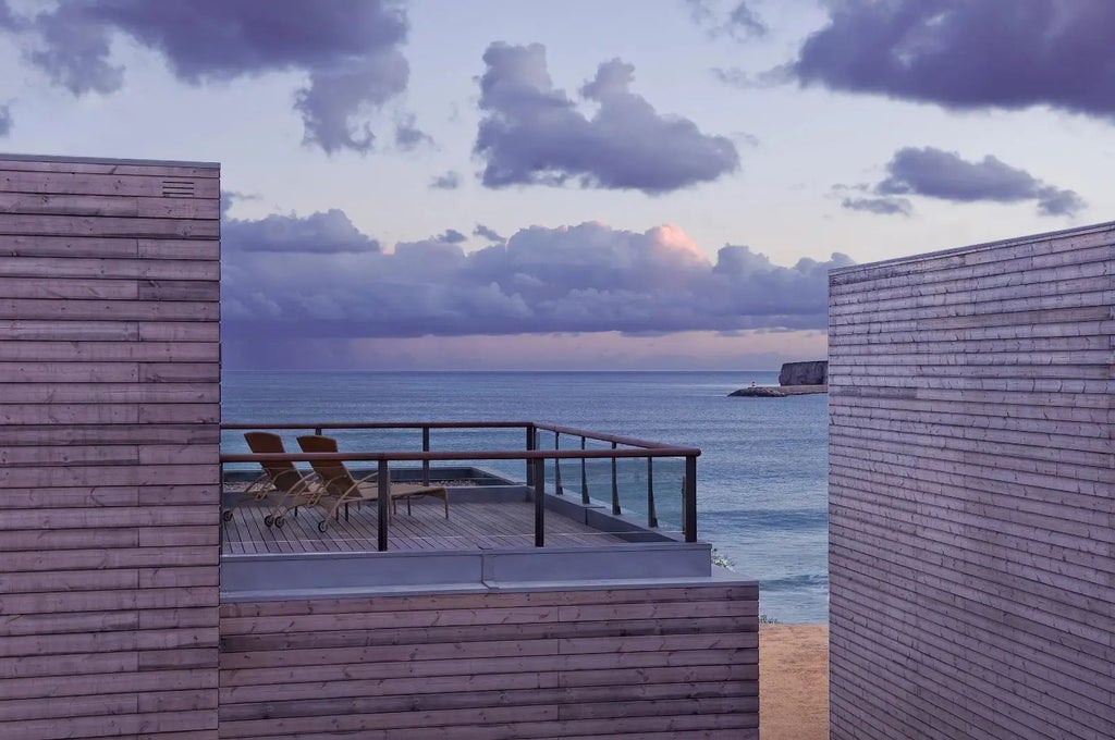 Spacious Martinhal Sagres Beach Suite with modern design, coastal view, plush white bedding, and elegant contemporary furnishings overlooking azure Portuguese coastline