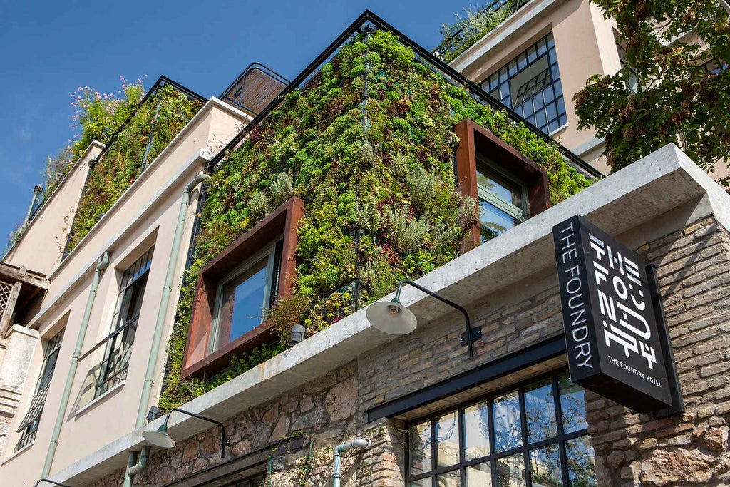 Elegant white marble hotel exterior with arched windows, private balconies, and Mediterranean-style architecture overlooking Athens cityscape