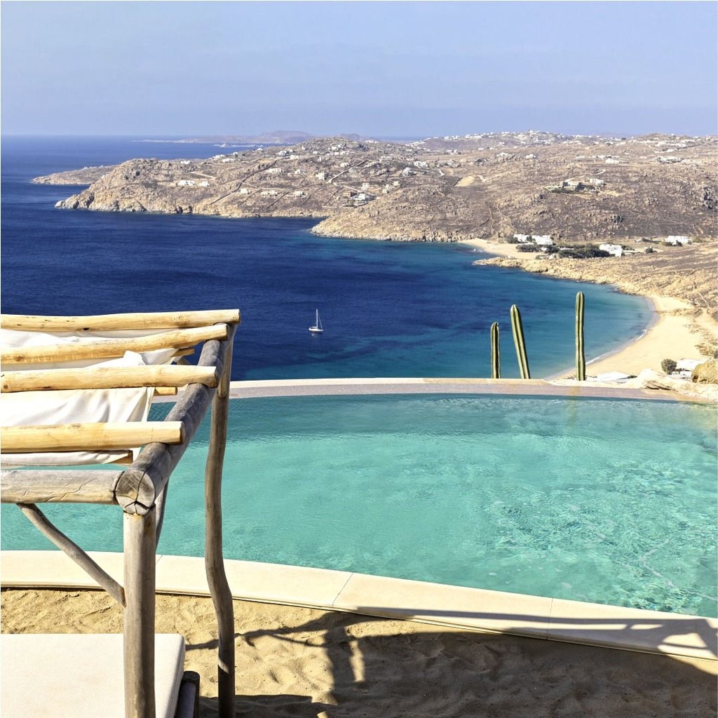 White luxury villa with infinity pool overlooking Aegean Sea, cascading terraces and minimalist architecture in Mykonos, Greece