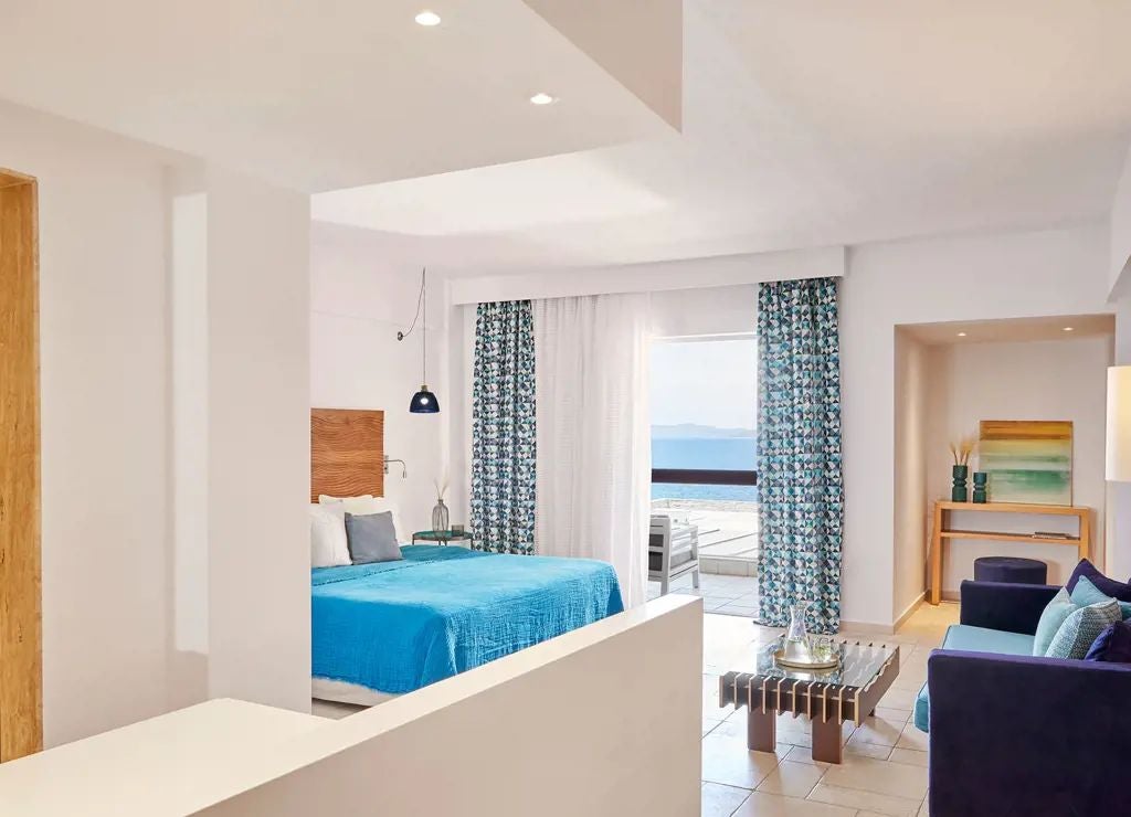 Luxurious panoramic sea view suite with elegant white furnishings, private balcony, and azure Aegean waters at Eagles Palace in Greece