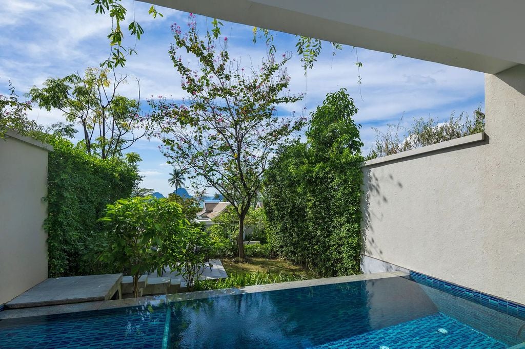 Modern twin-bed suite with private pool and garden views, featuring elegant Thai decor, glass doors, and luxurious seating area in Krabi