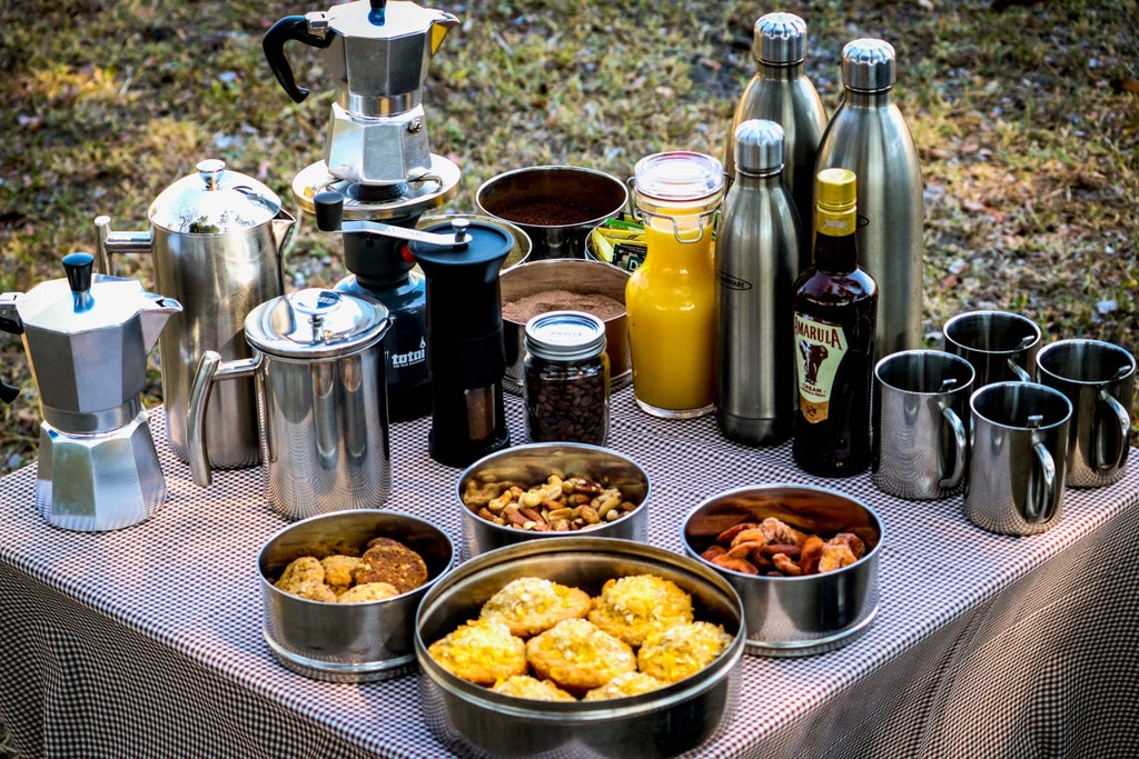 Elegant safari tent camp nestled in Botswana wilderness with canvas accommodations, wooden deck, and ambient lantern lighting at dusk