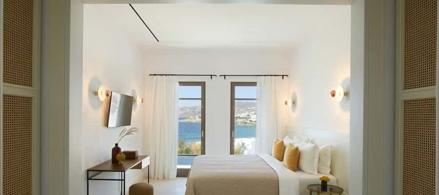 Luxurious one-bedroom villa in Mykonos with private heated pool, overlooking the Aegean Sea, featuring modern minimalist Greek island design and sunset views