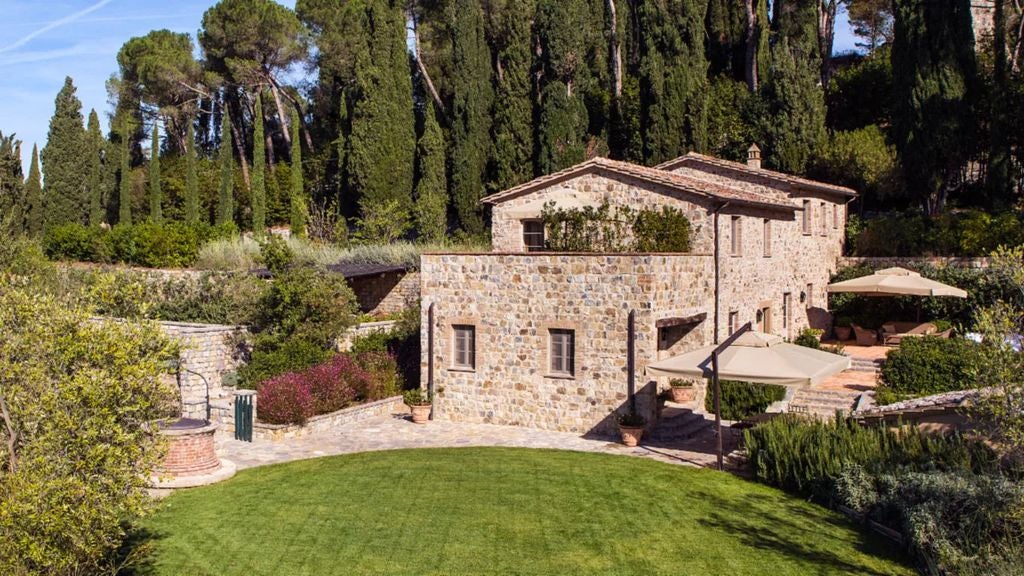 Elegant Tuscan luxury resort nestled in rolling hills, featuring stone architecture, manicured gardens and a serene infinity pool