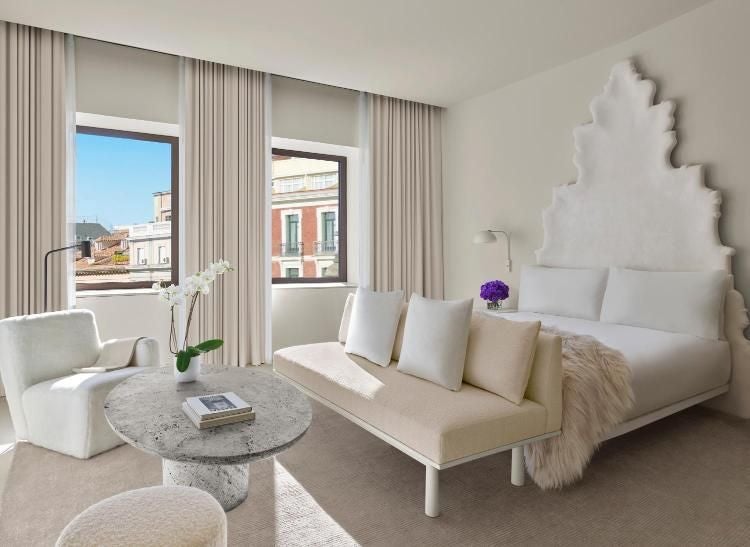 Elegant white marble facade of The Madrid EDITION hotel with classic Spanish architectural details and ornate balconies at dusk