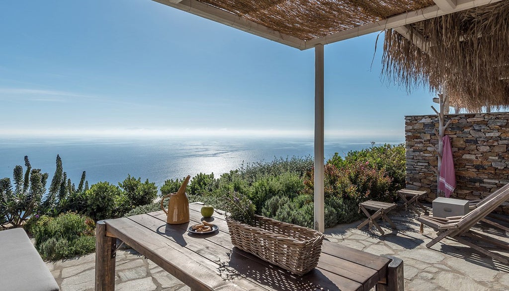 Minimalist white and blue Greek island hotel room with elegant bedding, sea view balcony, and soft natural lighting overlooking Sifnos landscape