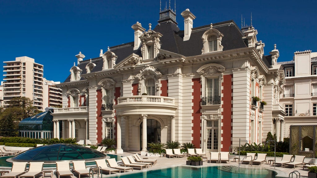 Elegant neoclassical facade of Four Seasons Buenos Aires with ornate columns, wrought-iron balconies and manicured garden entrance